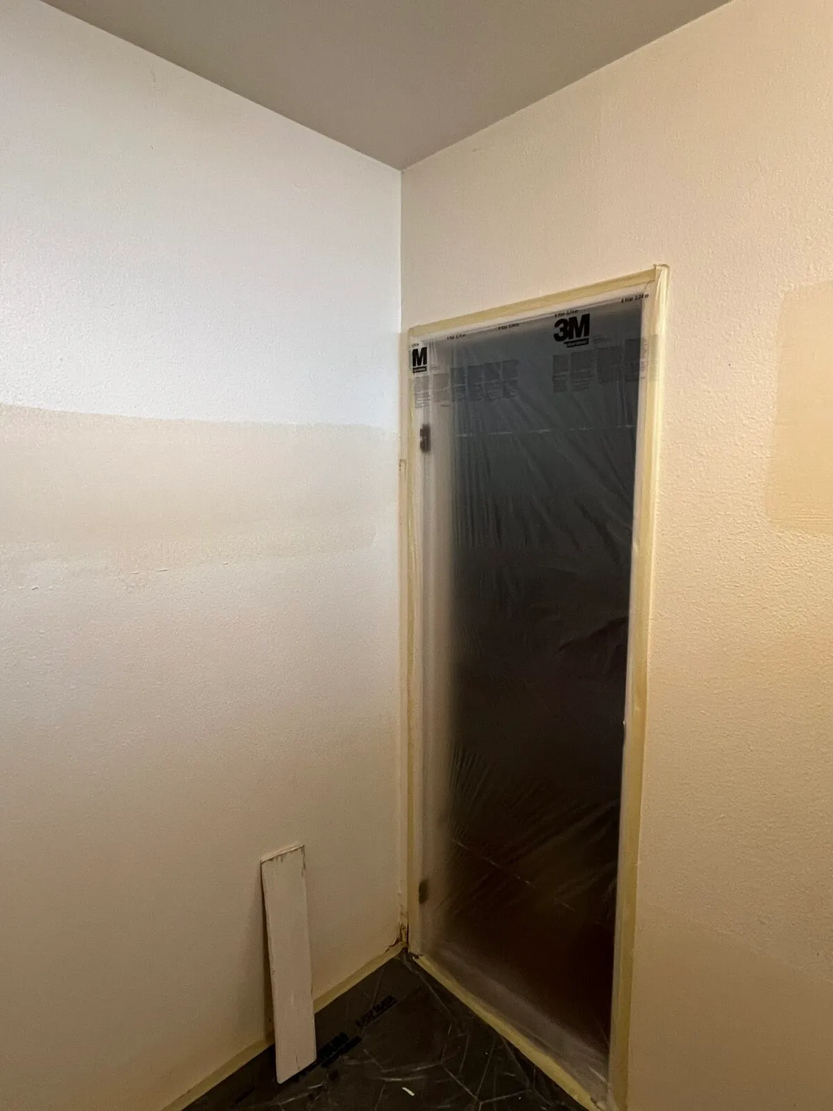 Bathroom remodel in progress with masked doorway protected from dust