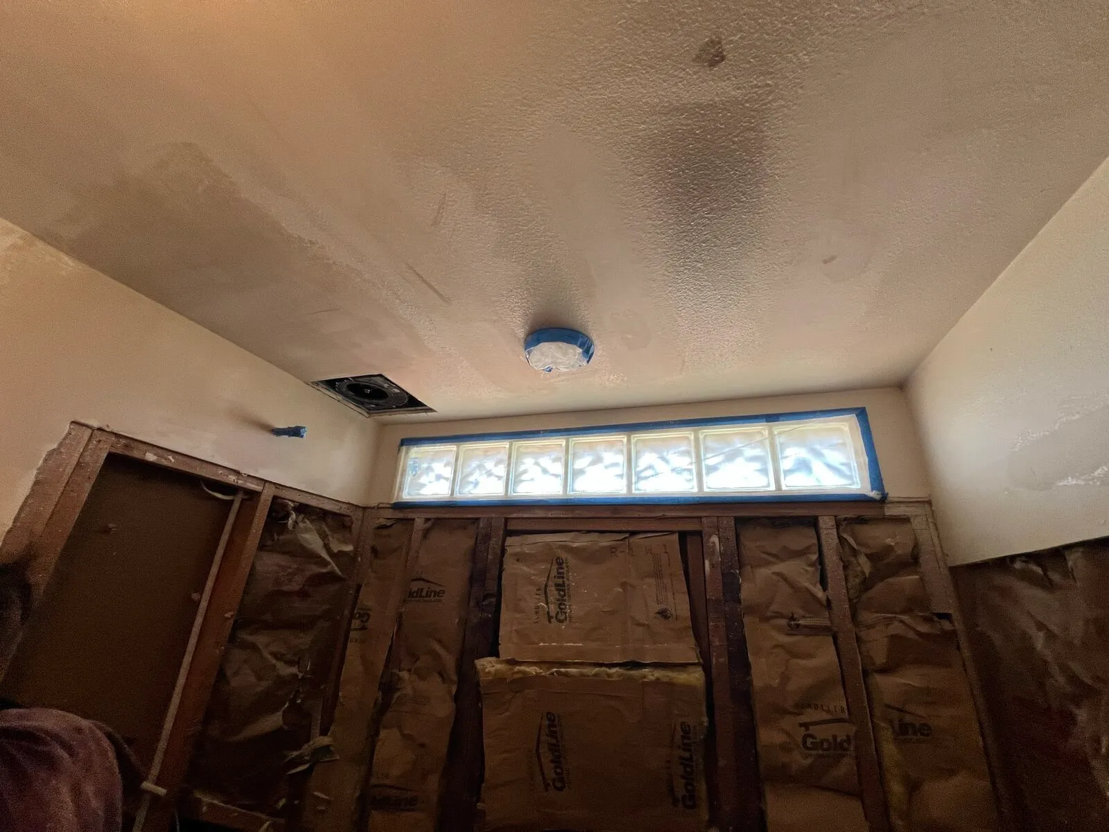 Drywall patches with built up mud near bathroom shower