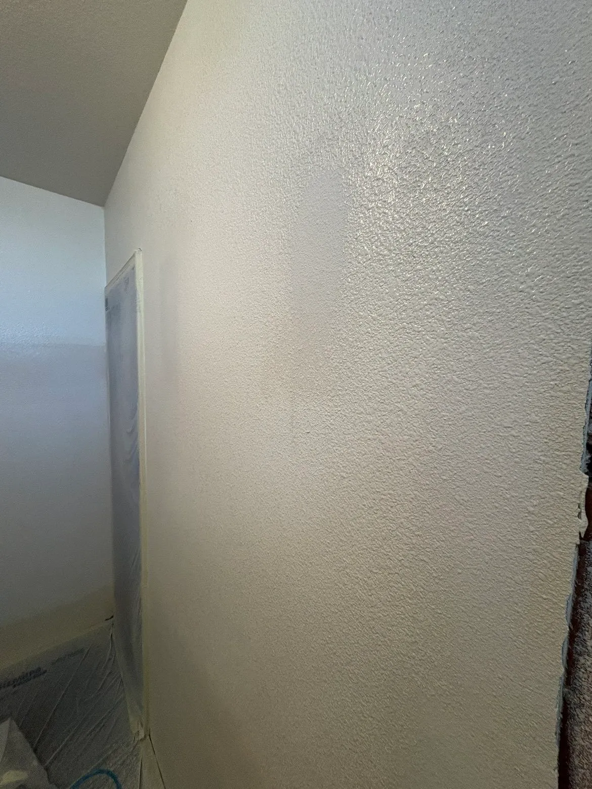 Patched and prepped bathroom wall with masked surroundings