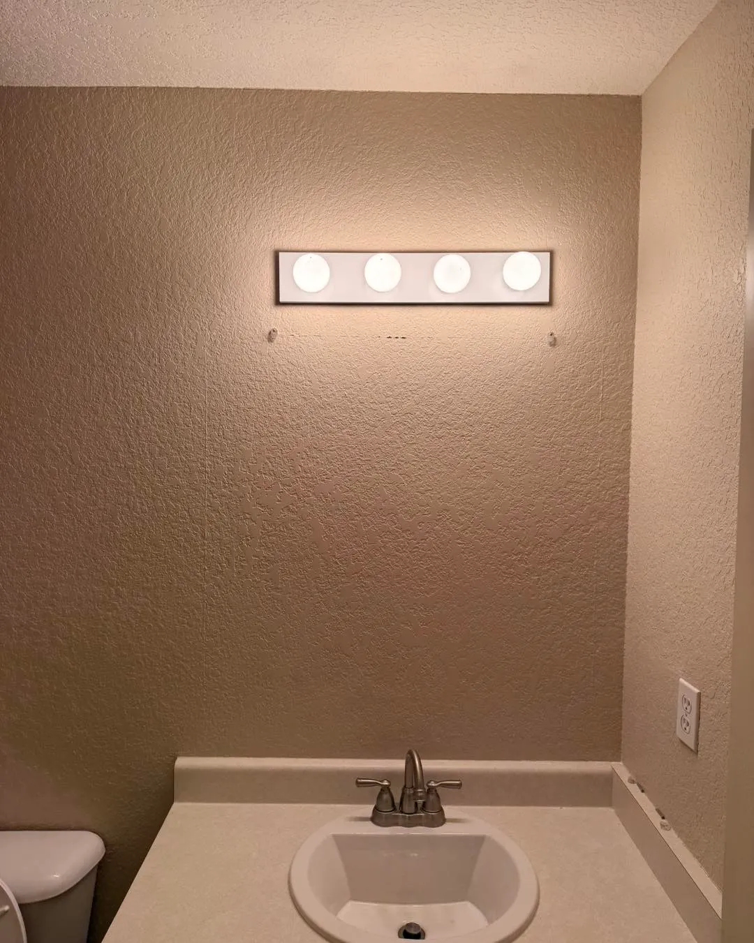 Bathroom wall completely restored with texture-matched finish, ready for mirror install