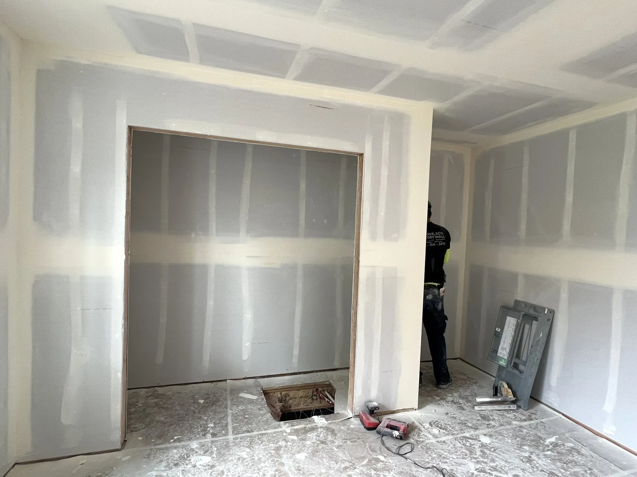 Crew member taping drywall seams in new construction project