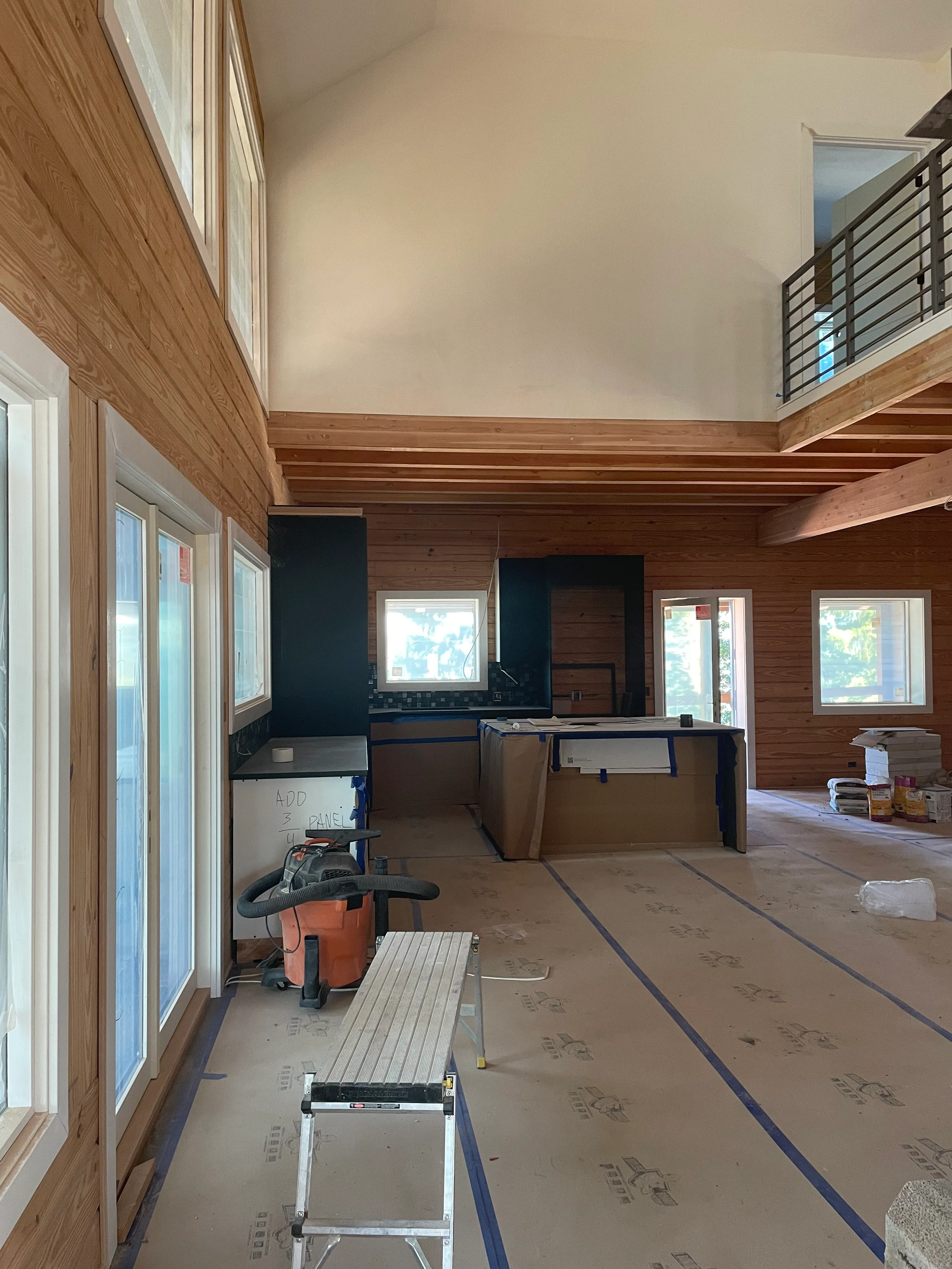 Custom home drywall installation with open concept loft and exposed cedar beams