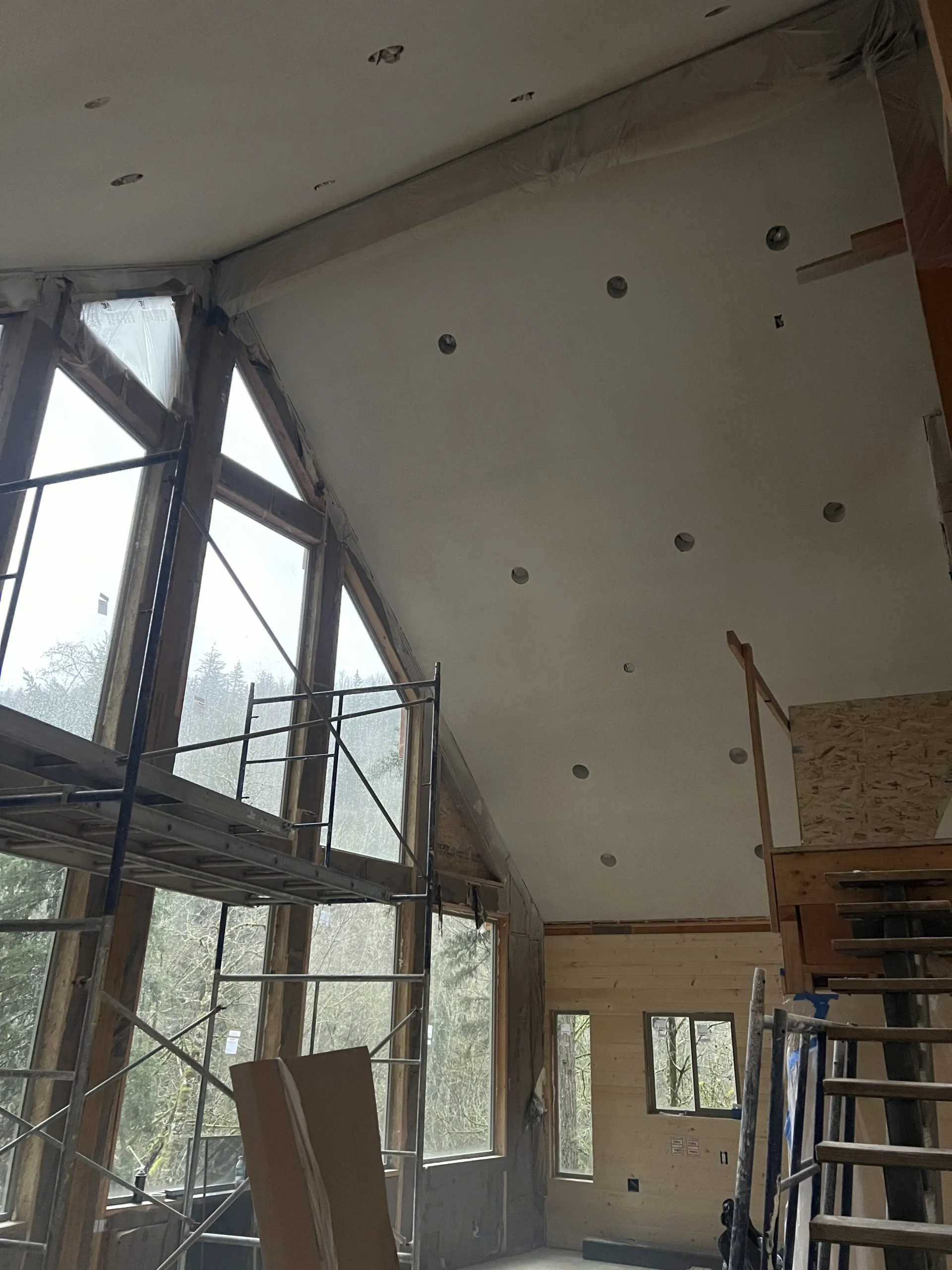 Vaulted ceiling drywall installation with scaffolding, A-frame home