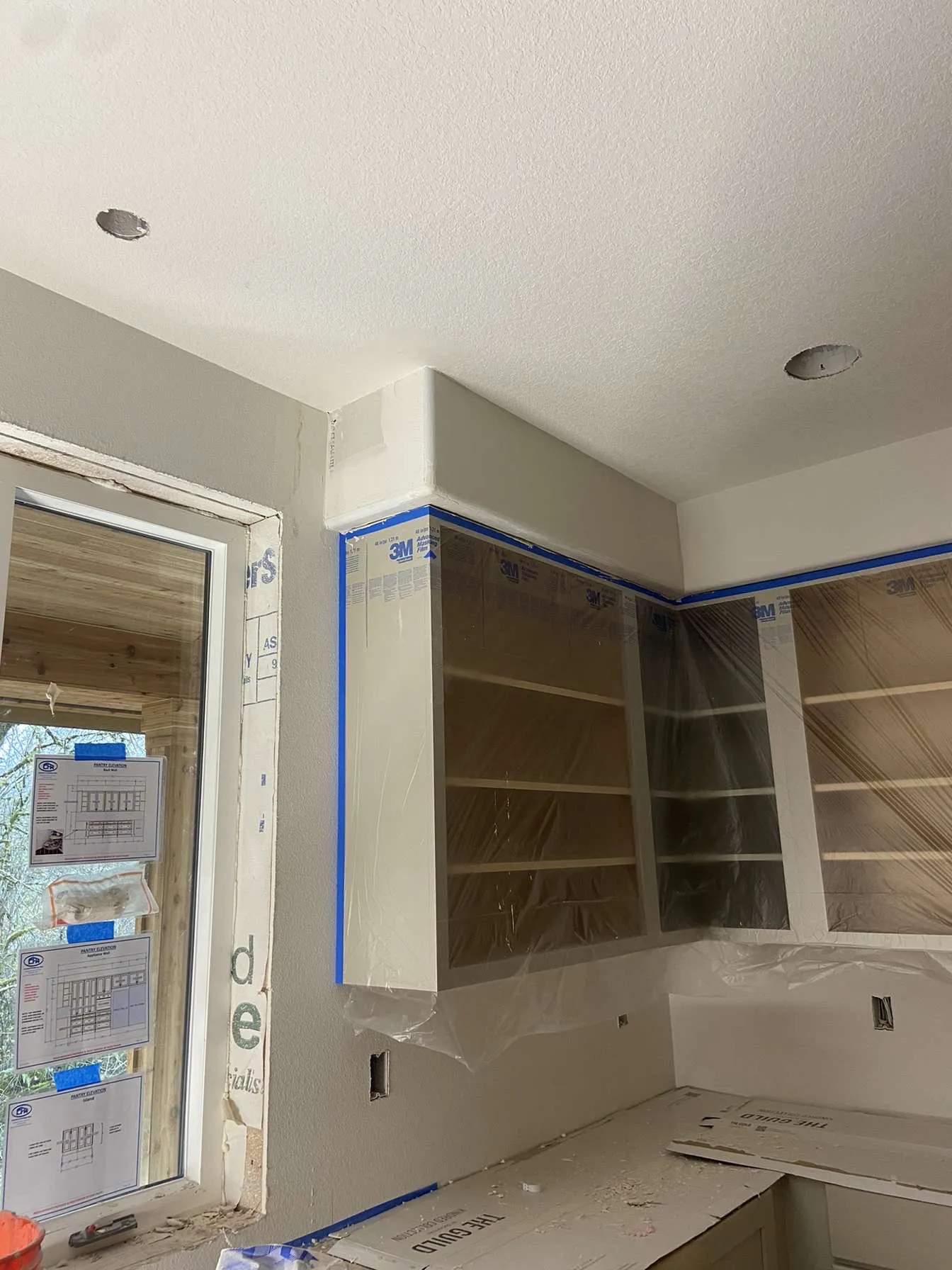 Kitchen soffit drywall finishing with cabinets masked