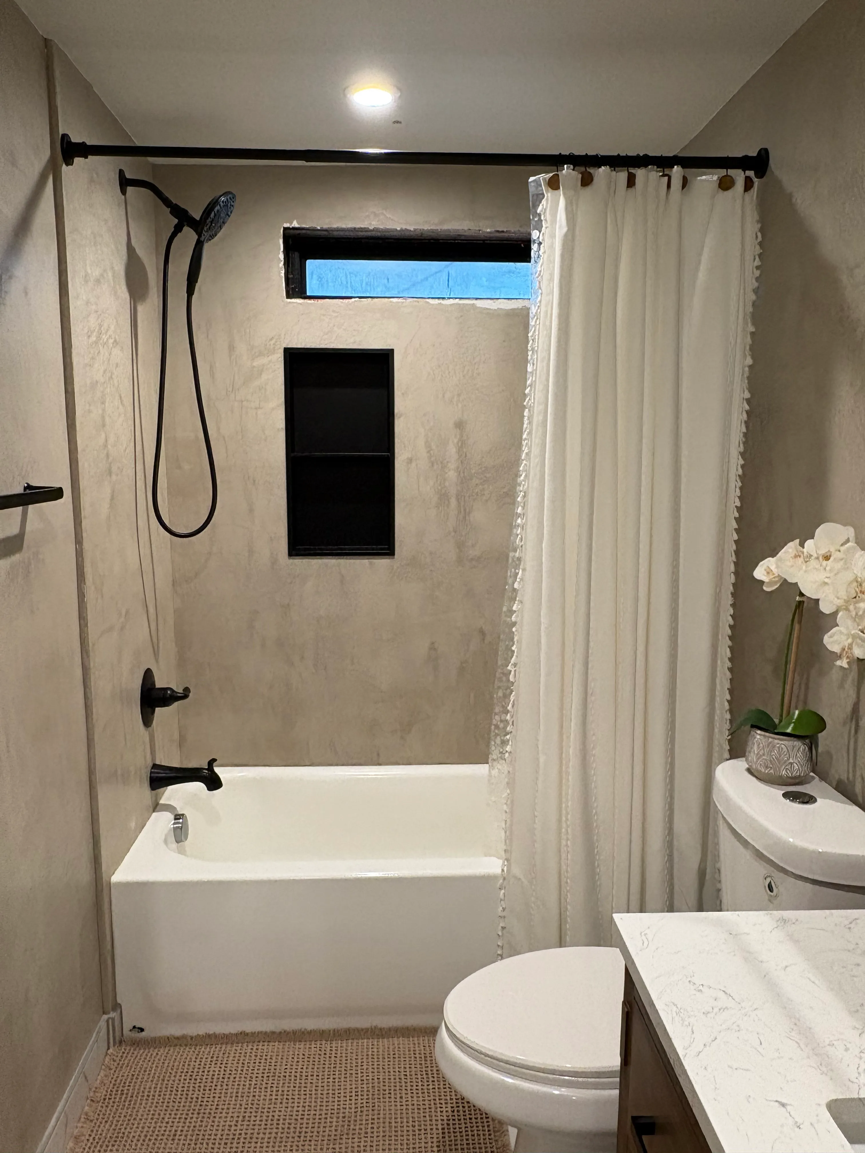 Decorative plaster shower surround with built-in niche applied over existing tile in Vancouver WA